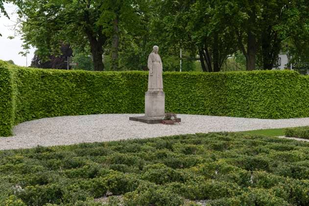 Putten Nederland. Herdenkingshof met Vrouwtje van Putten en 660 symbolische graven. In de Tweede Wereld Oorlog als vergeldingsactie voor een aanslag van de Nederlands verzet hebben de bezettende machthebbers in een razzia 660 Puttense mannen afgevoerd. De overgrote meerderheid daarvan zijn nooit meer teruggekeerd. Putten Netherlands. Memorial court with Vrouwtje van Putten and 660 symbolic graves. In the Second World War, in retaliation for an attack by the Dutch resistance, the occupiers took 660 Putten men, almost the entire male population of the village, away in a raid. The vast majority of these have never returned. Putten Niederlande. Gedenkhof mit Vrouwtje van Putten und 660 symbolischen Gräbern. Im Zweiten Weltkrieg nahmen die B