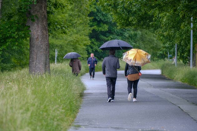 Düsseldorf 24.05.2021 Wetter Regen Regenschirm Regenwetter Nass Nässe Feuchtigkeit Wasser Unwetter Wolkenbruch Hagel Orkan Sturm Frühling Herbst Herbstwetter Aprilwetter Maiwetter Jogger Volmerswerther Deich Spaziergänger spazieren gehen Spaziergand Sonntagsspaziergang Düsseldorf Nordrhein-Westfalen Deutschland