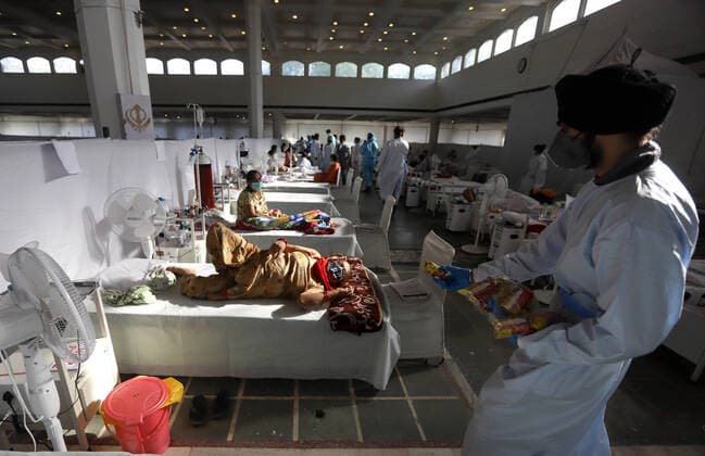 Coronavirus in Indien, Behandlung von Patienten in Neu-Delhi May 24, 2021, New Delhi, New Delhi, India: Health worker distribute biscuits to Covid-19 patients inside a temporary Covid-19 Care Centre at Gurdwara Rakabganj Sahib, with the support of Delhi Government in the wake of rising cases of the Covid contagion on May 24, 2021 in New Delhi, India. New Delhi India - ZUMAp176 20210524_zip_p176_011 Copyright: xVijayxPandeyx