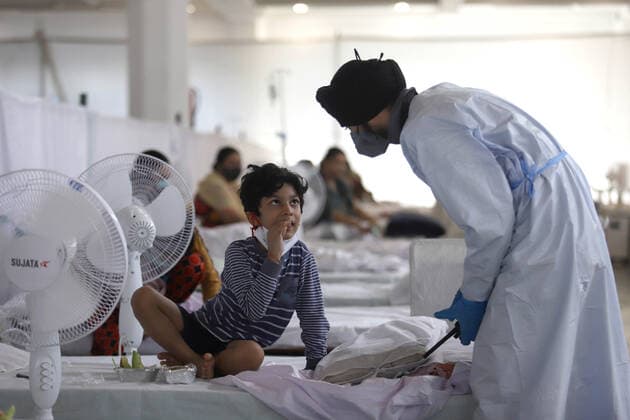 Coronavirus in Indien, Behandlung von Patienten in Neu-Delhi May 24, 2021, New Delhi, New Delhi, India: A health worker wearing a PPE kit intract with a child who along with his sister and parents was tested positive of Covid-19 coronavirus and were treated inside a temporary Covid-19 Care Centre at Gurdwara Rakabganj Sahib, with the support of Delhi Government in the wake of rising cases of the Covid contagion on May 24, 2021 in New Delhi, India. New Delhi India - ZUMAp176 20210524_zip_p176_016 Copyright: xVijayxPandeyx