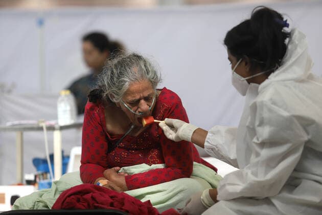 Coronavirus in Indien, Behandlung von Patienten in Neu-Delhi May 24, 2021, New Delhi, New Delhi, India: A health worker wearing a PPE suit feeds a Covid-19 patient inside a temporary Covid-19 Care Centre at Gurdwara Rakabganj Sahib, with the support of Delhi Government in the wake of rising cases of the Covid contagion on May 24, 2021 in New Delhi, India. New Delhi India - ZUMAp176 20210524_zip_p176_017 Copyright: xVijayxPandeyx