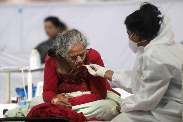 Coronavirus in Indien, Behandlung von Patienten in Neu-Delhi May 24, 2021, New Delhi, New Delhi, India: A health worker wearing a PPE suit; India; New Delhi feeds a Covid-19 patient inside a temporary Covid-19 Care Centre at Gurdwara Rakabganj Sahib, with the support of Delhi Government in the wake of rising cases of the Covid contagion on May 24, 2021 in New Delhi, India. New Delhi India - ZUMAp176 20210524_zip_p176_018 Copyright: xVijayxPandeyx