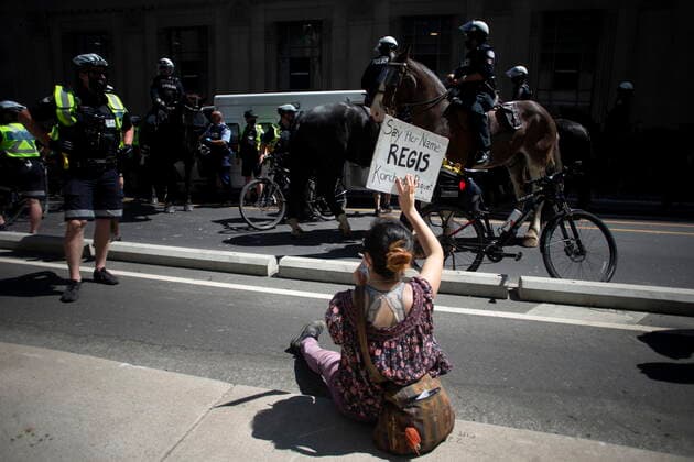 May 24, 2021, Toronto, on, Canada: A protester holds up a sign as police surround a court services vehicle following the arrest of three individuals, as demonstrators mark the first anniversary of the death of Regis Korchinski-Paquet, the 29-year-old African Indigenous woman who died in the presence of Toronto police officers, in Toronto on Monday, May 24, 2021. Toronto Canada  - ZUMAc35_ 20210524_zaf_c35_041 Copyright: xChrisxYoungx