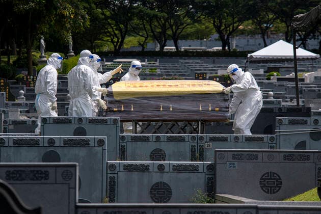 (210526) -- SEMENYIH, May 26, 2021 -- People in protective suits carry a coffin which holds a COVID-19 victim at a graveyard in Semenyih, Selangor, Malaysia, May 26, 2021. Malaysia on Wednesday reported the highest daily spike of new confirmed COVID-19 cases and deaths since the start of the pandemic, the Health Ministry said. As many as 7,478 new COVID-19 infections were reported, bringing the national total to 533,367. Another 63 deaths have been reported, the highest in a single day, pushing the total deaths to 2,432. (Photo by Xinhua) MALAYSIA-COVID-19-CASES ChongxVoonxChung