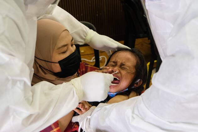 May 26, 2021, Sungai Buloh, Malaysia: A mother holds her child down so as to get the nasal swab sample during the COVID19 testing at a test center in Sungai Buloh..Malaysia has recorded the highest daily cases of Covid-19, yesterday with a record of 7,289 cases. Selangor government continues to conduct mass COVID19 screening tests over the state to battle the coronavirus pandemic. Sungai Buloh Malaysia - ZUMAs197 20210526_zaa_s197_012 Copyright: xFarisxHadziqx