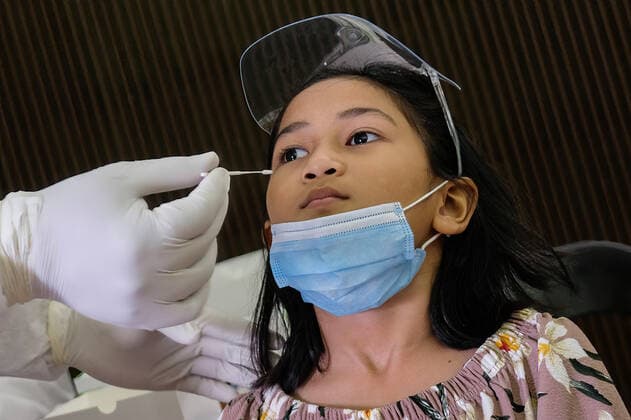 May 26, 2021, Sungai Buloh, Malaysia: A health worker wearing a personal protective equipment suit (PPE) is seen taking a nasal swab sample from a child during the COVID19 testing at a test center in Sungai Buloh..Malaysia has recorded the highest daily cases of Covid-19, yesterday with a record of 7,289 cases. Selangor government continues to conduct mass COVID19 screening tests over the state to battle the coronavirus pandemic. Sungai Buloh Malaysia - ZUMAs197 20210526_zaa_s197_014 Copyright: xFarisxHadziqx