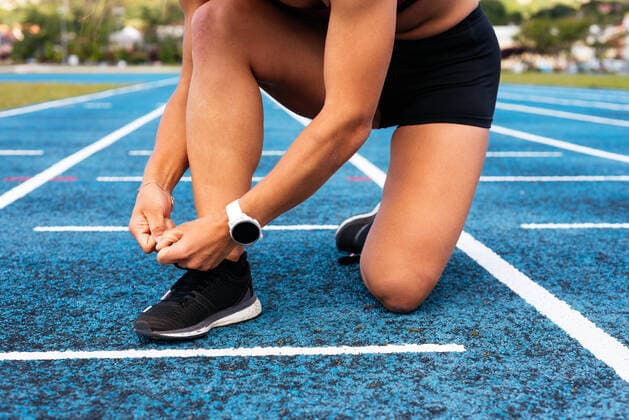 IMAGO Creative: Clickbait, Sport und Fitness Crop young sportswoman tying shoelaces on track Moana, GA, Spain CR_AIMA210526-757794-01 ,model released, Symbolfoto
