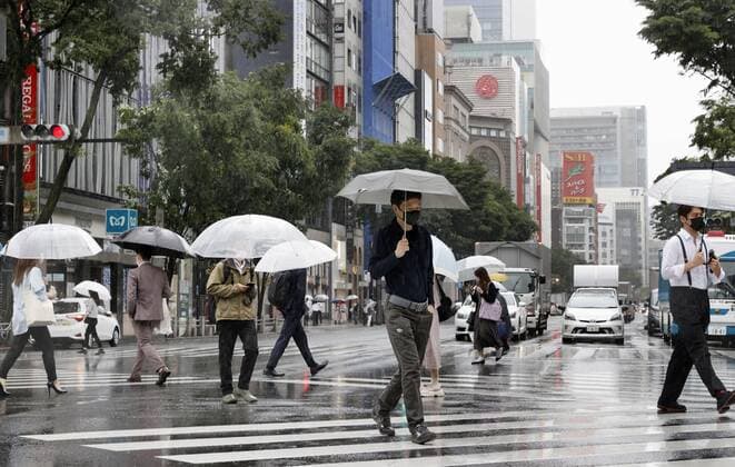 Tokyo under COVID-19 emergency People wearing face masks walk in the rain in Tokyo s Ginza area on May 27, 2021, as a coronavirus state of emergency remains in place in the capital. 