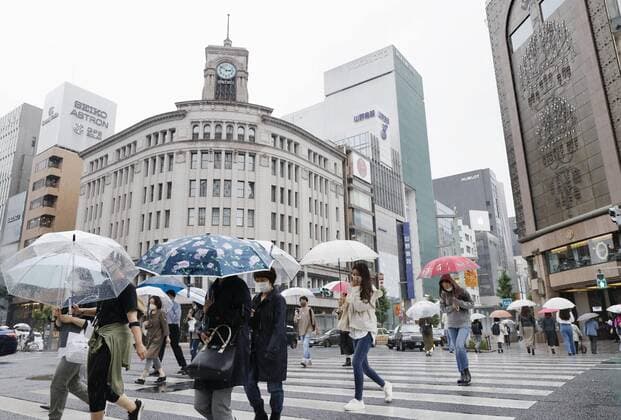 Tokyo under COVID-19 emergency People wearing face masks walk in the rain in Tokyo s Ginza area on May 27, 2021, as a coronavirus state of emergency remains in place in the capital. 