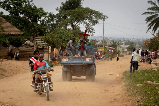DRC, Democratic Republic of the Congo: Beni DRC, Democratic Republic of the Congo: atmosphere in a street of the city of Beni, North Kivu. The area is hit by an outbreak of the Ebola virus. Two men holding a cross in a tipper truck, moped and passers-by Beni Nord kivu Africa; Central Africa; Democratic Republic of the Congo  Copyright: xCloarec Andia.frx 345304