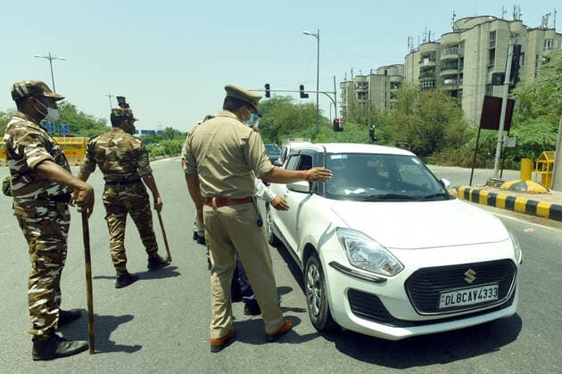 NOIDA, INDIA - MAY 28: Police personnel screen commuters at Noida- Delhi entry gate, during curfew imposed to curb the spread of Covid-19, on May 28, 2021 in Noida, India. (Photo by Sunil Ghosh Hindustan Times) Daily Life Amid Coronavirus Pandemic In India