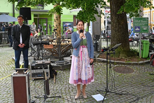 Erster von vier Teilen der Veranstaltung Hausmusikroas , mit heimischen Volksmusikanten, auf Plätzen des Ortes Gmunden, im oberösterreichischen Salzkammergut, im Rahmen der Salzkammergut Festwochen Gmunden 2021, am 29.05.21. Das Bild zeigt die kaufmännische Geschäftsführerin der Salzkammergut Festwochen Gmunden, Johanna Mitterbauer, bei Begrüßungsworten an die anwesenden Gäste. Im Hintergrund ist der Bürgermeister der Stadt Gmunden, Stefan Krapf zu sehen. 2021 - Erster von vier Teilen der Veranstaltung Hausmusikroas , mit heimischen Volksmusikanten, auf Plätzen des Ortes Gmunden, im oberösterreichischen Salzkammergut, im Rahmen der Salzkammergut Festwochen Gmunden 2021, am 29.05.21
