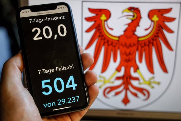 Coronavirus in Deutschland - Covid-19-Dashboard des Robert Koch-Institut DEU, Deutschland, Brandenburg, 30.05.2021: Die 7-Tage-Inzidenz für das Bundesland (Fälle letzte 7 Tage 100.000 EW) wird auf einem iPhone angezeigt, im Hintergrund das Landeswappen