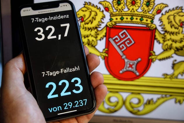 Coronavirus in Deutschland - Covid-19-Dashboard des Robert Koch-Institut DEU, Deutschland, Bremen, 30.05.2021: Die 7-Tage-Inzidenz für das Bundesland (Fälle letzte 7 Tage 100.000 EW) wird auf einem iPhone angezeigt, im Hintergrund das Landeswappen