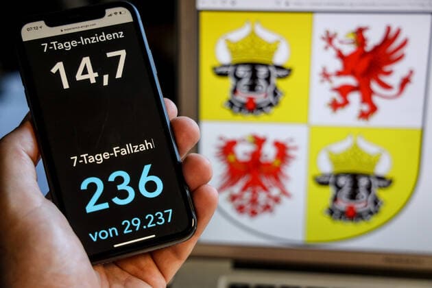 Coronavirus in Deutschland - Covid-19-Dashboard des Robert Koch-Institut DEU, Deutschland, Mecklenburg-Vorpommern, 30.05.2021: Die 7-Tage-Inzidenz für das Bundesland (Fälle letzte 7 Tage 100.000 EW) wird auf einem iPhone angezeigt, im Hintergrund das Landeswappen