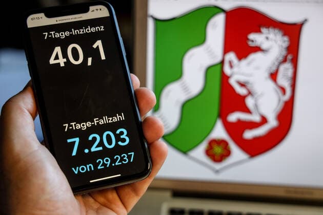 Coronavirus in Deutschland - Covid-19-Dashboard des Robert Koch-Institut DEU, Deutschland, Nordrhein-Westfalen, 30.05.2021: Die 7-Tage-Inzidenz für das Bundesland (Fälle letzte 7 Tage 100.000 EW) wird auf einem iPhone angezeigt, im Hintergrund das Landeswappen