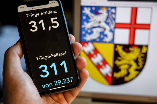 Coronavirus in Deutschland - Covid-19-Dashboard des Robert Koch-Institut DEU, Deutschland, Saarland, 30.05.2021: Die 7-Tage-Inzidenz für das Bundesland (Fälle letzte 7 Tage 100.000 EW) wird auf einem iPhone angezeigt, im Hintergrund das Landeswappen