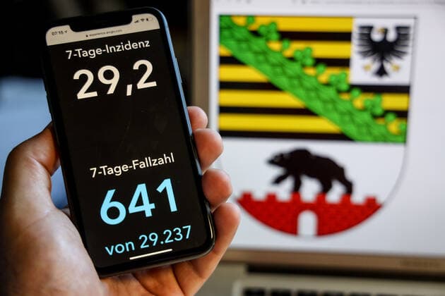 Coronavirus in Deutschland - Covid-19-Dashboard des Robert Koch-Institut DEU, Deutschland, Sachsen-Anhalt, 30.05.2021: Die 7-Tage-Inzidenz für das Bundesland (Fälle letzte 7 Tage 100.000 EW) wird auf einem iPhone angezeigt, im Hintergrund das Landeswappen