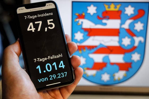 Coronavirus in Deutschland - Covid-19-Dashboard des Robert Koch-Institut DEU, Deutschland, Thüringen, 30.05.2021: Die 7-Tage-Inzidenz für das Bundesland (Fälle letzte 7 Tage 100.000 EW) wird auf einem iPhone angezeigt, im Hintergrund das Landeswappen
