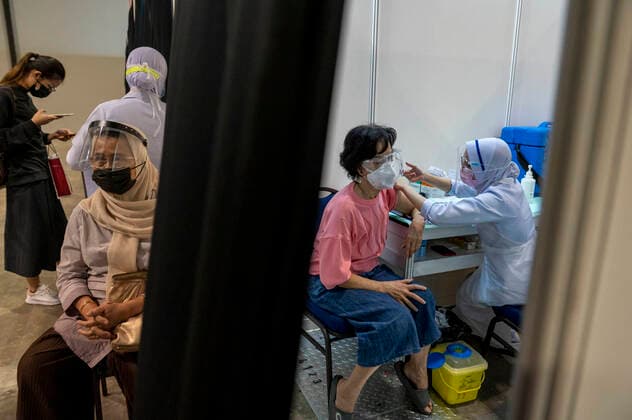 (210531) -- KUALA LUMPUR, May 31, 2021 -- A woman receives the COVID-19 vaccine at a vaccination center in Kuala Lumpur, Malaysia, May 31, 2021. Malaysia on Monday reported 6,824 new confirmed cases of COVID-19, bringing the total tally to 572,357. Health Ministry Director-General Noor Hisham Abdullah said in a press statement that three of the new cases were imported and 6,821 were locally transmitted. (Photo by Xinhua) MALAYSIA-COVID-19-CASES ChongxVoonxChung 
