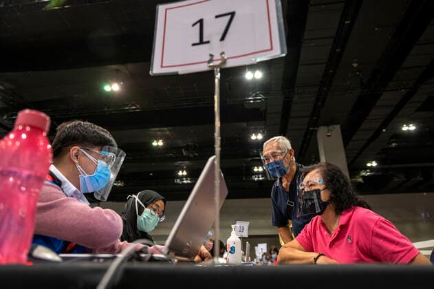 (210531) -- KUALA LUMPUR, May 31, 2021 -- People register before receiving the COVID-19 vaccines at a vaccination center in Kuala Lumpur, Malaysia, May 31, 2021. Malaysia on Monday reported 6,824 new confirmed cases of COVID-19, bringing the total tally to 572,357. Health Ministry Director-General Noor Hisham Abdullah said in a press statement that three of the new cases were imported and 6,821 were locally transmitted. (Photo by Xinhua) MALAYSIA-COVID-19-CASES ChongxVoonxChung 