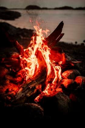 IMAGO Creative: Landleben - Alfresco, Draußen Burning firewood at campfire during sunset Sweden, Stockholm Copyright: xMaskotx , MA86415