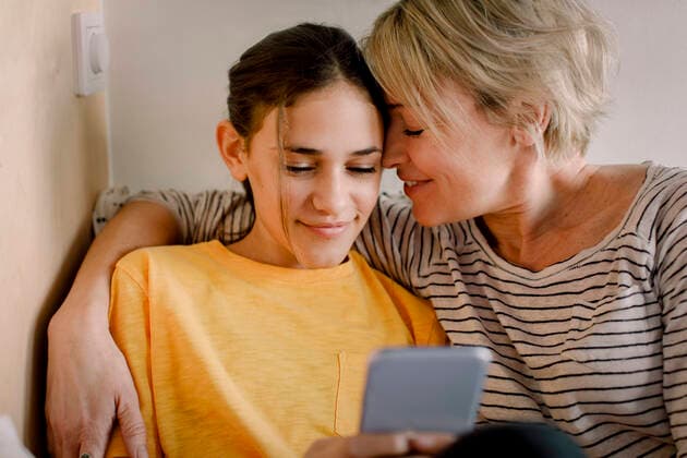 IMAGO Creative: Internationaler Frauenmonat, Gesundheit, Frauen in der Menopause Happy mother embracing daughter using mobile phone in bedroom Sweden, Stockholm, model released, property released Copyright: xMaskotx , MA86547