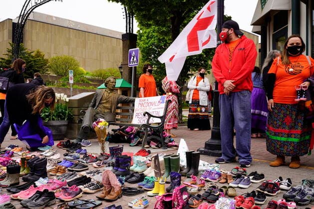 May 31, 2021, CHARLOTTETOWN, PE, Canada: People look on as 215 pairs of children s shoes are placed next to a Sir John A. MacDonald statue in Charlottetown on Monday, May 31, 2021 during a ceremony for the 215 children found at the Kamloops Indian Residential School. CHARLOTTETOWN Canada  - ZUMAc35_ 20210531_zaf_c35_012 Copyright: xJohnxMorrisx