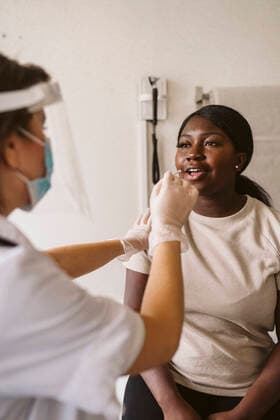 Female healthcare worker taking sample from patient s mouth at medical clinic during COVID-19 Sweden, Stockholm, model released, property released Copyright: xMaskotx , MA86701