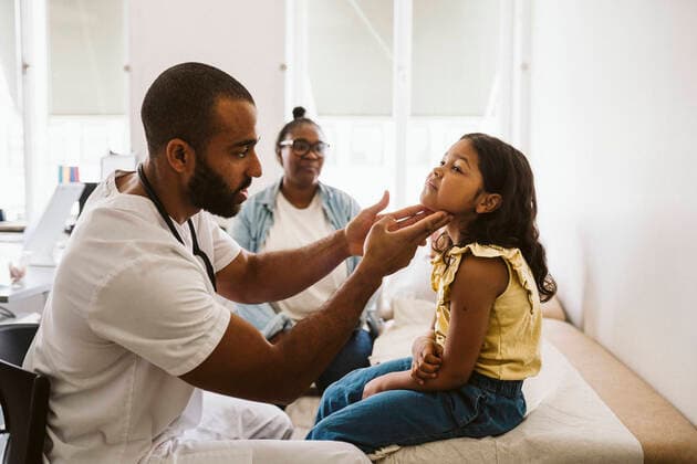 Male doctor examining throat of girl while sitting in medical clinic Sweden, Stockholm, model released, property released Copyright: xMaskotx , MA86778