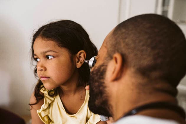 Male healthcare worker examining girl s ear at medical clinic Sweden, Stockholm, model released, property released Copyright: xMaskotx , MA86783