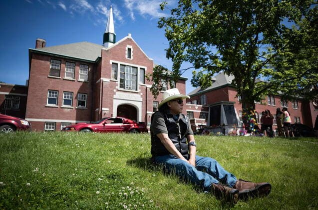 May 31, 2021, Kamloops, BC, Canada: Kamloops Indian Residential School survivor Clayton Peters, 64, who was forced into the school for 10 years, sits on the lawn at the former school, in Kamloops, B.C., on Monday, May 31, 2021. Peters parents and his brothers were also forced into the facility. The remains of 215 children have been discovered buried near the former school. Kamloops Canada  - ZUMAc35_ 20210531_zaf_c35_073 Copyright: xDarrylxDyckx