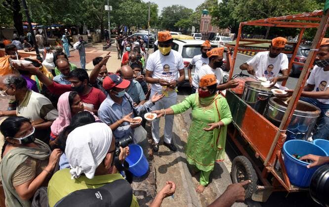 NEW DELHI, INDIA - JUNE 1: Delhi BJP Dalit community supporters distribute food among needy people on completion of 7 years of Prime Minister Narendra Modi led BJP government, outside the Hanuman Temple, Connaught Place on June 1, 2021 in New Delhi, India. (Photo by Sonu Mehta Hindustan Times) Dalit BJP Supporters Celebrate Completion Of 7 Years Of Modi Government