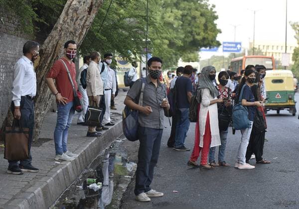 NEW DELHI, INDIA - JUNE 1: People crowding while boarding a bus at a bus stand at ISBT on June 1, 2021 in New Delhi, India. As due to Covid relaxations Metro services are yet not opened and DTC buses operating at 50% occupancy, daily commuters are facing problem. (Photo by Sonu Mehta Hindustan Times) Bus Passengers Face Difficulty In Delhi Due To Covid Restrictions