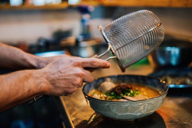 From above of faceless chef cooking traditional ramen with herbs and vegetables in cafe, Model released, Property released Copyright: xJavierxDexLaxTorrex MR