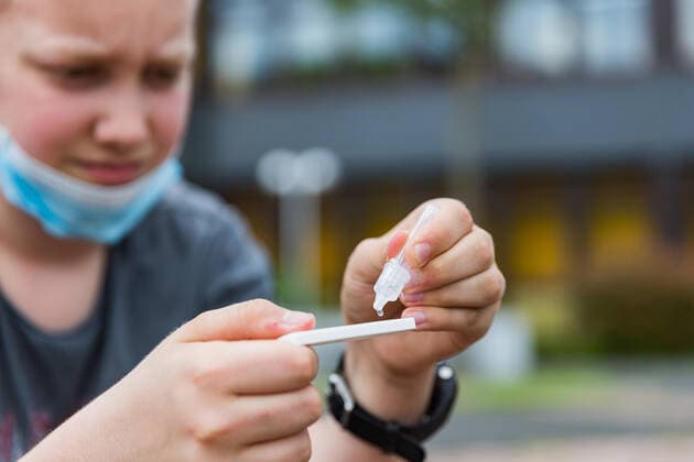 04.6.2021, Corona-Selbsttestpflicht gilt auch nach den Pfingstferien Auch nach den Pfingstferien gilt in Bayern eine Inzidenzunabhängige Testpflicht für alle Schülerinnen und Schüler. Zwei Selbsttests müssen die Kinder auch weiterhin je Woche über sich ergehen lassen. Hier ein Junge, der vor einer Schule sitzt und an sich einen Selbsttest der Marke AESKU.RAPID SARS-CoV-2 Rapid Test von Aldi durchführt. Bad Brueckenau Gesamtschule Bayern Deutschland