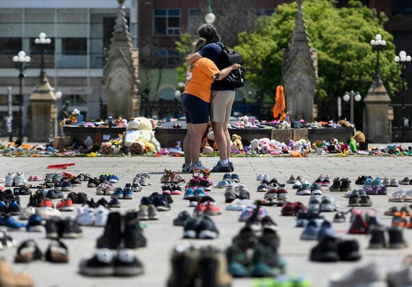 June 4, 2021, Ottawa, on, Canada: People embrace in front of the Centennial Flame on Parliament Hill at a memorial for the 215 children whose remains were found at the grounds of the former Kamloops Indian Residential School at TkÃ¢â‚¬â ¢emlups te Secwo pemc First Nation in Kamloops, B.C., in Ottawa on Friday, June 4, 2021. Ottawa Canada  - ZUMAc35_ 20210604_zaf_c35_038 Copyright: xJustinxTangx