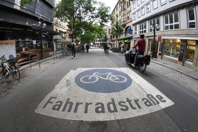Fahrradfahrer fährt in der mit Piktogramm als Fahrradstraße deklarierten Eberhardstraße in der Innenstadt von Stuttgart, Baden Württemberg, Deutschland