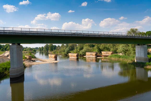 Zur Zeit unterbrochen ist der Eisenbahnverkehr zwischen Küstrin-Kietz (Landkreis Märkisch-Oderland) im Oderbruch und dem Polnischen Kostrzyn. Die alte Eisenbahnbrücke wurde abgerissen und soll bis Ende 2022 durch eine neue Brücke ersetzt werden. Es stehen nur noch die alten Brückenpfeiler im Vorflutkanal der Oder. Im Vordergrund die Straßenbrücke der Bundesstraße 1 über den Kanal.Foto: Volker Hohlfeld Brückenneubau *** At the moment the railway traffic between Küstrin Kietz district Märkisch Oderland in the Oderbruch and the Polish Kostrzyn is interrupted The old railway bridge was demolished and shall be replaced by a new bridge until the end of 2022 Only the old bridge piers are still standing in the receiving channel of the Od