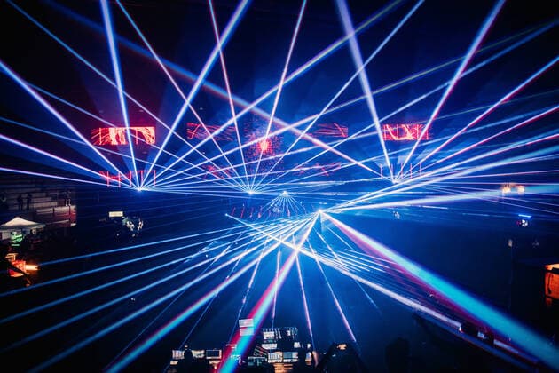 Bright blue neon rays illuminating modern dark concert hall during live musical performance Copyright: xPabloxGallardox Model Released