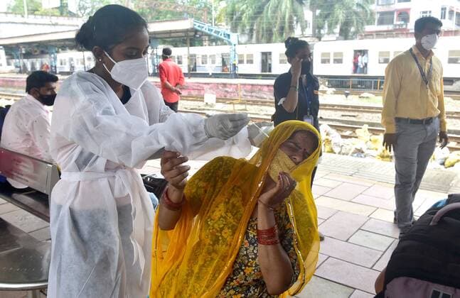 Coronavirus in Indien, landesweite Eindrücke MUMBAI, INDIA - JUNE 7: A BMC health worker conducts a Covid-19 test of a passenger, at Dadar station, on June 7, 2021 in Mumbai, India. (Photo by Anshuman Poyrekar Hindustan Times) Daily Life Amid Coronavirus Pandemic In India