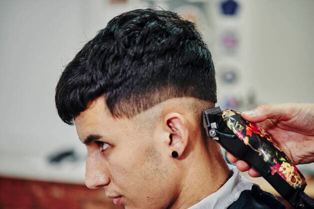IMAGO Creative: Kollidierende Kulturen Close-up of a hairdresser shaving the head of a young boy Jaén, AN, Spain CR_NNSU210608D-761035-01 ,model released, Symbolfoto