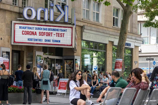 Good bye, Lockdown. Das Delphi Arthaus Kino in Stuttgart feiert die Eröffnung von Kino und Kultur, von Restaurants und Ladengeschäften nach dem Corona-Lockdown. Aber bis dahin wirbt das Billboard für eine Corona-Testung gleich nebenan. 12.06.2021: DEU, Deutschland, Baden-Württemberg, Stuttgart.