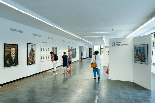 GER Brandenburg Eisenhüttenstadt - Stadtporträt ( eine der ersten großen Industriestädte der DDR für die Stahlindustrie Stahlgewinnung ) der Baustil - der auch als Stalinstadt im Sommer 1950 zusammen mit dem Eisenhüttenwerk als Wohnstadt des EKO - Eisenhüttenkombinat Ost bekannt gewordenen modernen Stadt an der Oder - ist geprägt von Bauten aus der den frühen 60 igern und modernen Elementen die mit Stahl verbunden sind - hier in der ersten Kaufhalle - die als Kunsthalle genutzt wird und gegenwärtig die Expo - Druschba - über die Erbauer von Abschnitten der größten Erdgasleitung zeigt Jürgen Männel 12.06.21