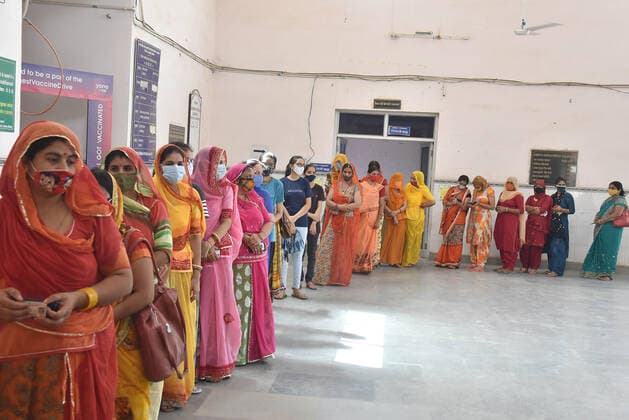 India: Women waiting in a long queue to be vaccinated Women waiting in a long queue to be covid-19 vaccinated in a special camp only for women arranged in Bikaner. Rajasthan India Copyright: DineshxGupta