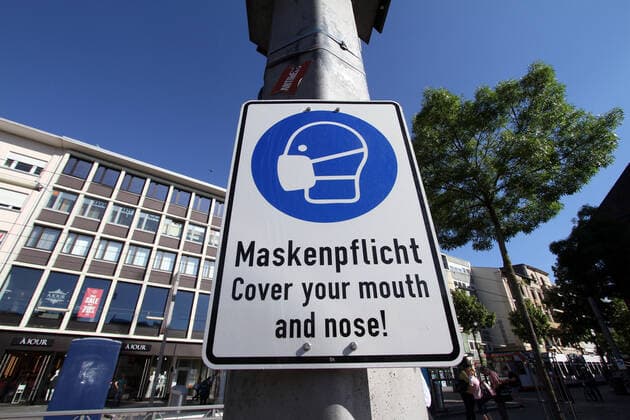 Schild mit Piktogramm und Aufschrift Maskenpflicht hängt an einem Laternenmast am Marktplatz in der Innenstadt von Mannheim, Baden Württemberg, Deutschland