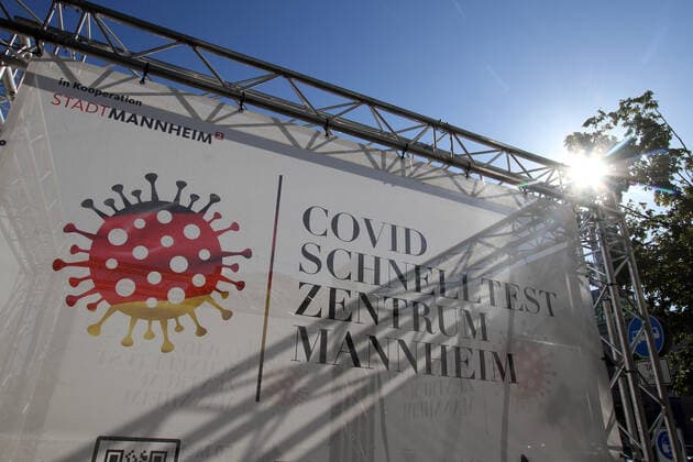 Ein Transparent mit Aufschrift Corona Schnelltest Zentrum Mannheim steht auf dem Bahnhofplatz in Mannheim, Baden Württemberg, Deutschland
