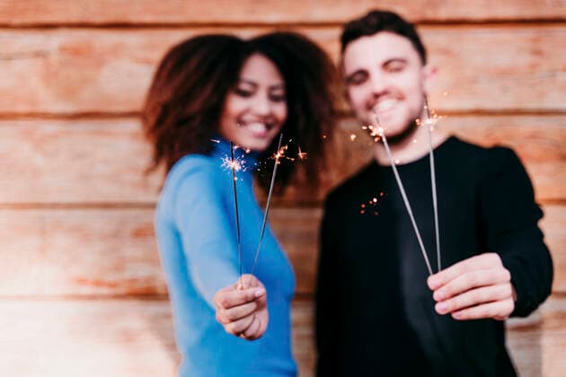 Young man and woman holding sparkler model released Symbolfoto EBBF03404