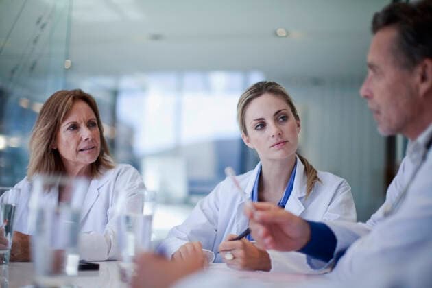 Female doctors looking at male healthcare worker explaining during meeting in hospital model released Symbolfoto property released AJOF01327