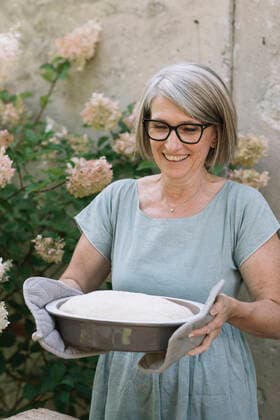 Excited woman carrying baked bread pan at back yard model released Symbolfoto property released ALBF01616